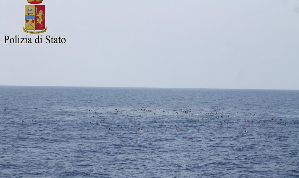 Inmigrantes supervivientes del naufragio de su barcaza, con 700 personas a bordo, nadando en el mar frente a las costas de Libia .-REUTERS /Policía de Italia