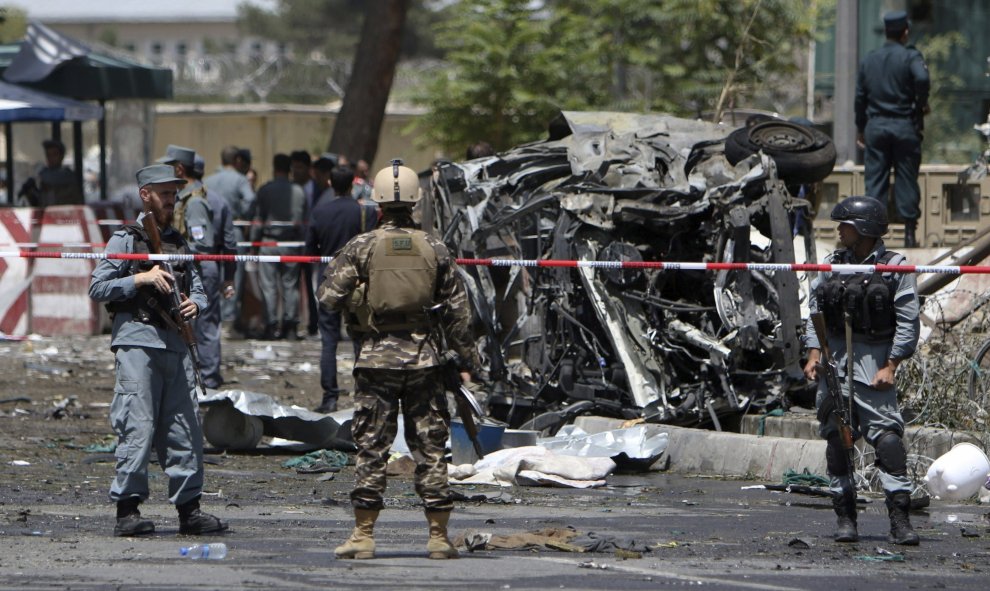 Miembos de los servicios de seguridad afganos inspeccionan el lugar donde un conductor suicida hizo detonar los explosivos que portaba en su coche, en el control de seguridad del aeropuerto Internacional de Kabul, Afganistán, hoy, 10 de agosto de 2015. EF