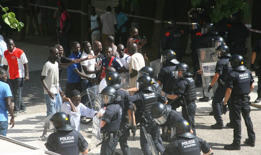 Los compañeros del senegalés fallecido esta mañana increpan a los Mossos, que han respondido con cargas. EFE/Jaume Sellart