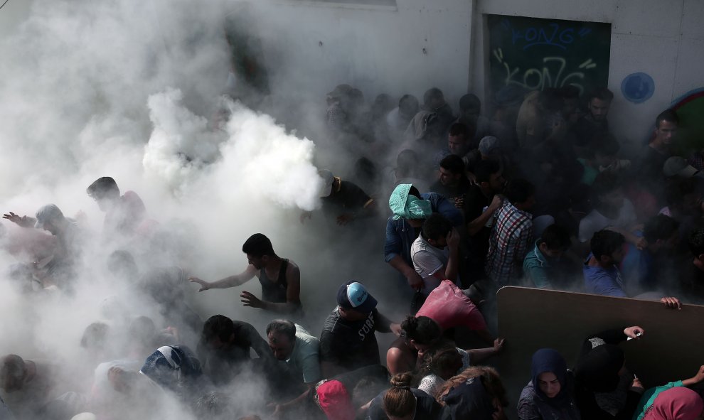 Cientos de inmigrantes son rociados con extintores por la policía en el los enfrentamientos en el estadio donde se llevaba a cabo un procedimiento de registro, en la isla griega de Cos, el 11 de agosto de 2015. AFP / ANGELOS TZORTZINIS
