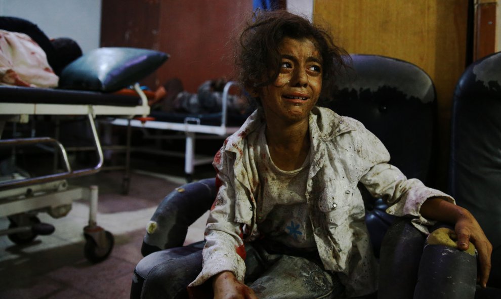 Una niña siria llora en un hospital improvisado en la zona controlada por los rebeldes en Douma, al este de Damasco, tras los ataques aéreos por las fuerzas del régimen, el 12 de agosto de 2015. AFP PHOTO / ABD DOUMANY