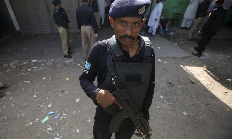 Un policía hacia guardia mientras que otros investigan un tiroteo en un restaurante en Karachi, Pakistán 12 de agosto de 2015.REUTERS/Athar Hussain