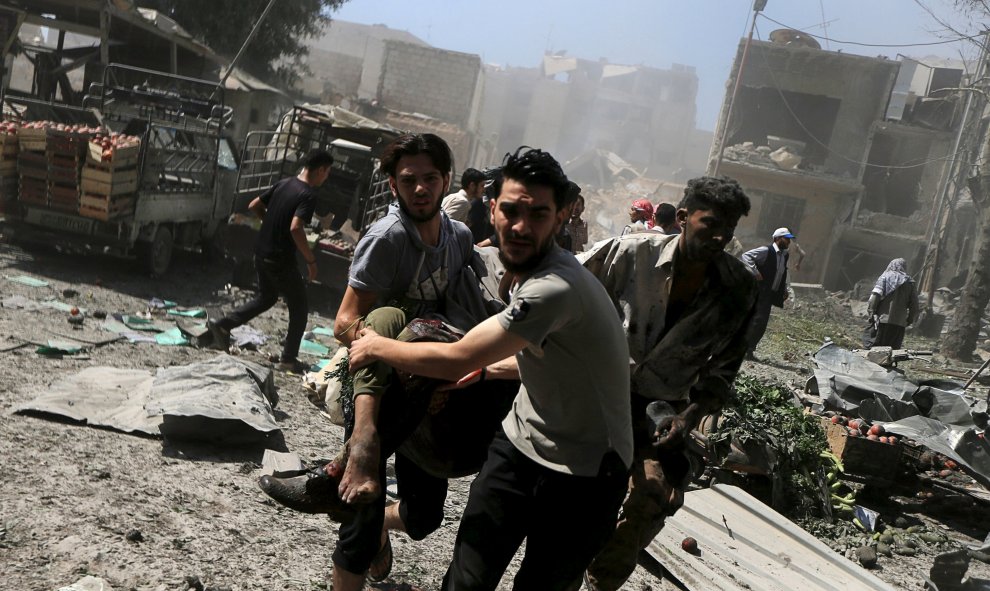 Varios hombres llevan una víctima en brazos después de los ataques aéreos de las fuerzas leales al presidente de Siria, Bashar al- Assad, en un concurrido mercado en el barrio de Douma de Damasco, Siria 12 de agosto de 2015. REUTERS / Bassam Khabieh