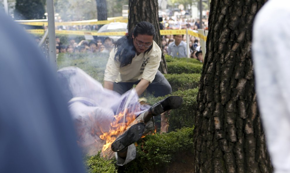 Un hombre intenta apagar las llamas de otro hombre (parte inferior) que se prendió fuego durante una manifestación contra Japón en Seúl, Corea del Sur.-REUTERS / Kim Hong-Ji