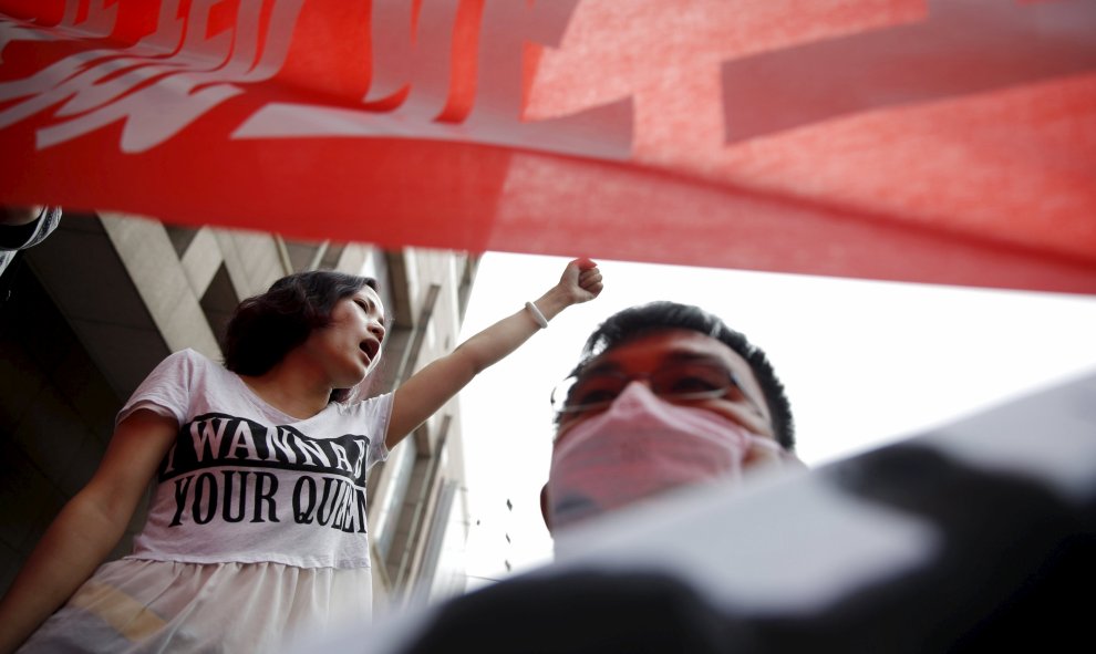 Una mujer alza el puño en señal de protesta contra el Gobierno chino, al que la manifestación de este lunes acusaba de abandonar a los afectados. REUTERS