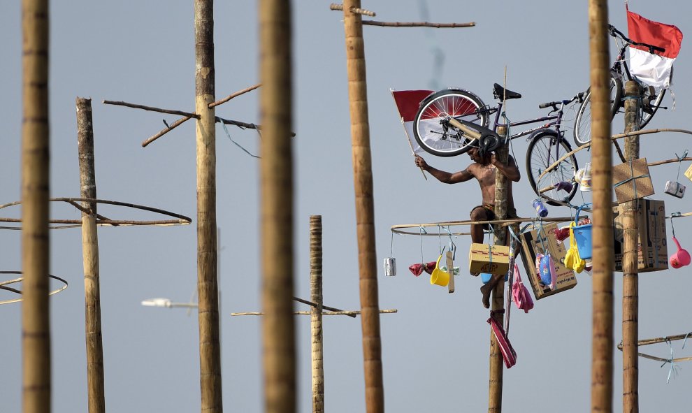 Un hombre sube un poste para recuperar premios en la parte superior durante la fiesta para conmemorar el 70º aniversario dela independencia de Indonesia en Yakarta, Indonesia 17 de agosto 2015./ REUTERS / sigid Kurniawan / Antara Foto