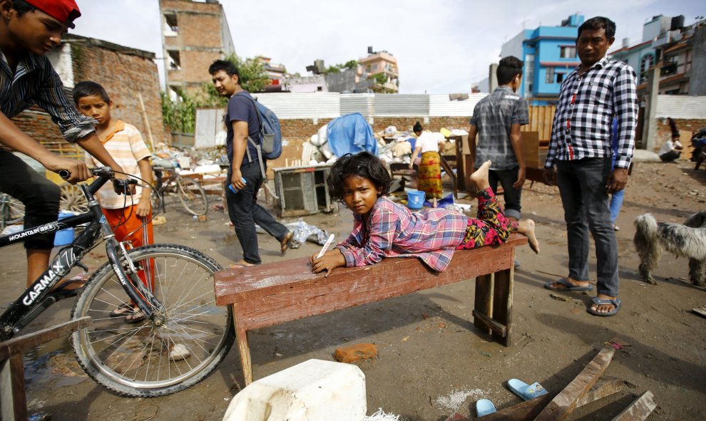 Una niña tumbada en un banco cerca de la orilla del río Bagmati después de las inundaciones causadas por las fuertes lluvias en Katmandú, Nepal 17 de agosto de 2015. REUTERS / Navesh Chitrakar