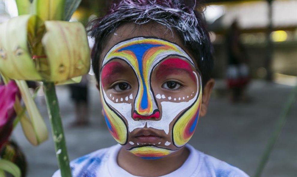 Un niño posa con la cara pintada durante el ritual de Gerebeg en Gianyar, Bali, Indonesia. La celebración tiene el objetivo de alejar a todos los espíritus malvados de las ciudades y se celebra cada seis meses. EFE/Made Nagi