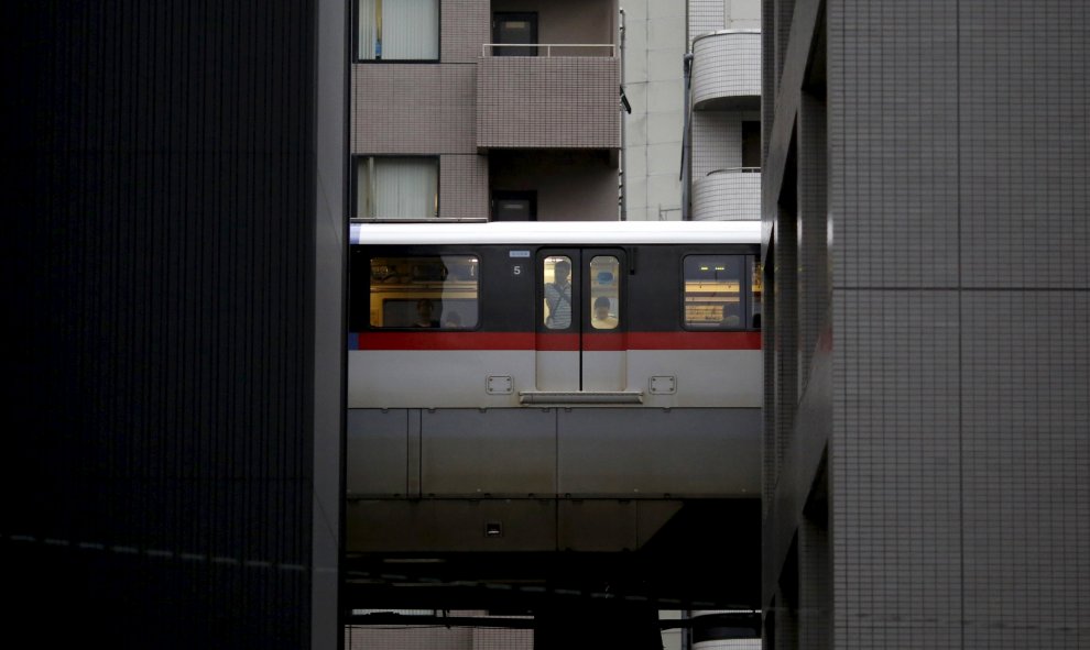 Un hombre mira por la ventana del tren entre dos edificios en Tokio, 26 de agosto, 2015. REUTERS/Toru Hanai