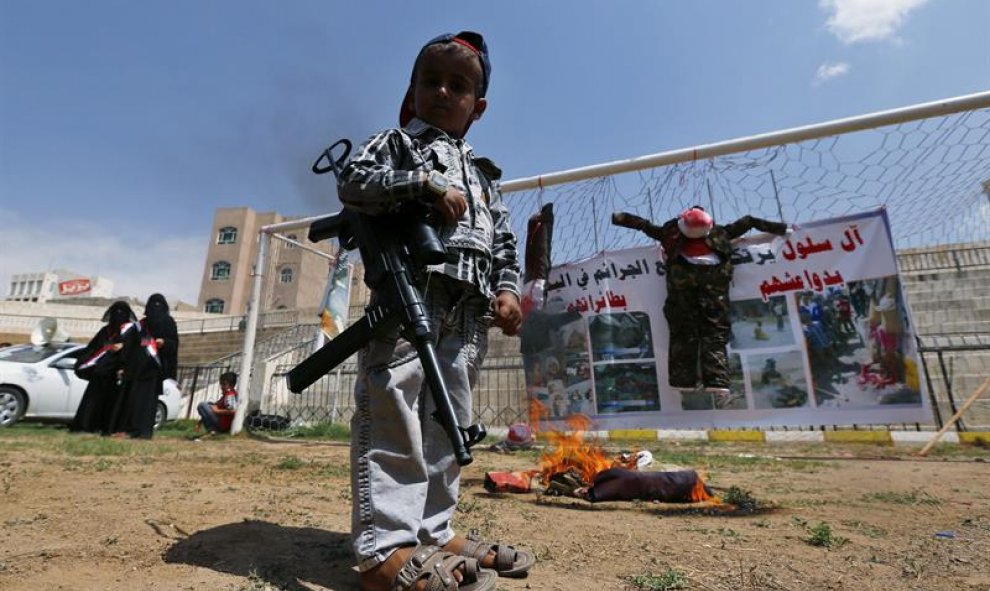 Un niño sujeta un arma durante una manifestación para denunciar el ataque de la coalición árabe liderada por Arabia Saudí contra varias posiciones de los hutíes en Saná, Yemen, hoy 26 de agosto de 2015. EFE/Yahya Arhab