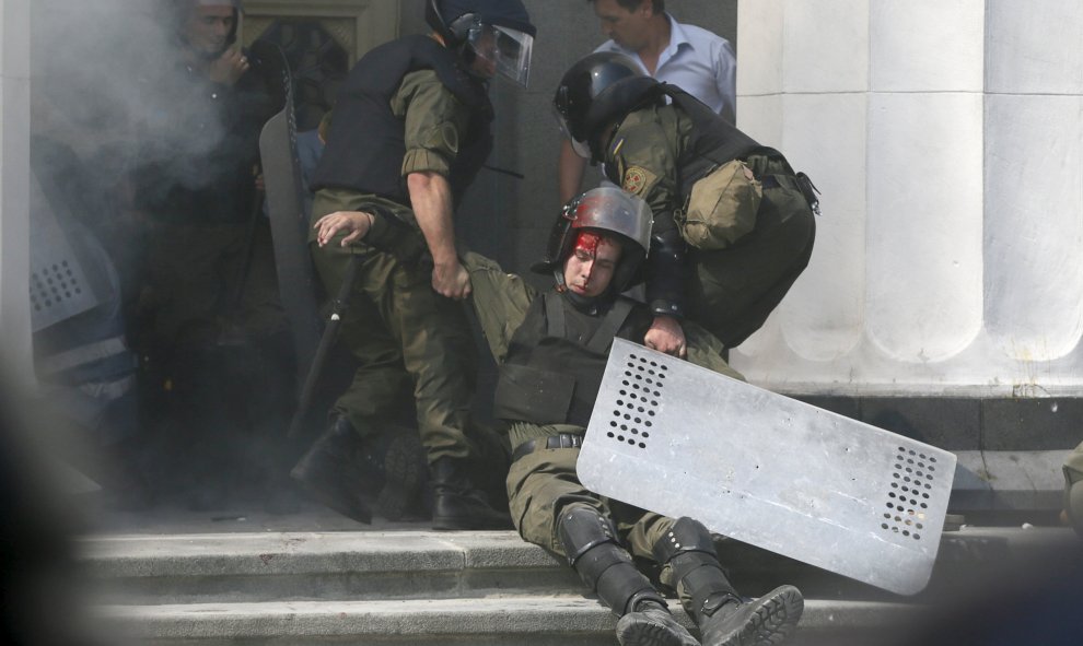 Un oficial de la guardia nacional herido se deja llevar por los compañeros en el edificio del parlamento en Kiev tras el ataque de este lunes, Ucrania, 31 de agosto de 2015./REUTERS / Valentyn Ogirenko