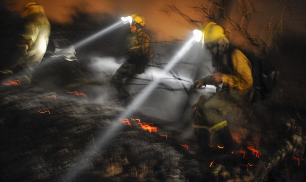 Tres brigadistas realizan labores de extinción ayer en el incendio forestal, registrado en Cualedro, en el sur de la provincia de Ourense, que ha quemado más de 2.000 hectáreas de terreno forestal. EFE/Brais Lorenzo