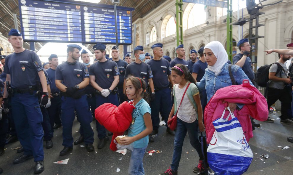 Los refugiados abandonan la estación ante las órdenes de las autoridades, que impiden que suban a los trenes. REUTERS