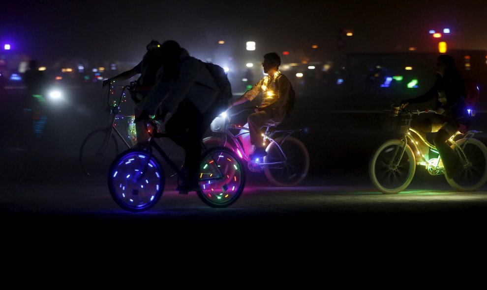 Fiesteros iluminan sus bicicletas para el viaje nocturno en la Playa durante el "Burning Man 2015", el festival de espectáculos, arte y música  llamado Carnaval de Espejos, en el desierto de Nevada anoche. REUTERS/Jim Urquhart