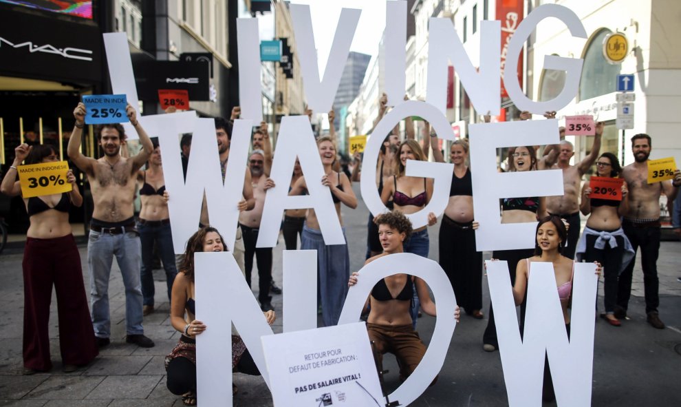 Activistas de "LKicing Wage Now" se quitan la ropa durante una manifestación en Bruselas (Bélgica) hoy. Exigen una mejora de las condiciones de trabajo y una paga justa para los trabajadores de la industria textil. EFE/Olivier Hoslet