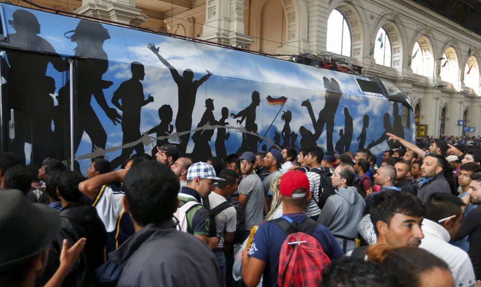 Cientos de refugiados intentan subirse a un tren en la estación de Keleti (Budapest). /REUTERS