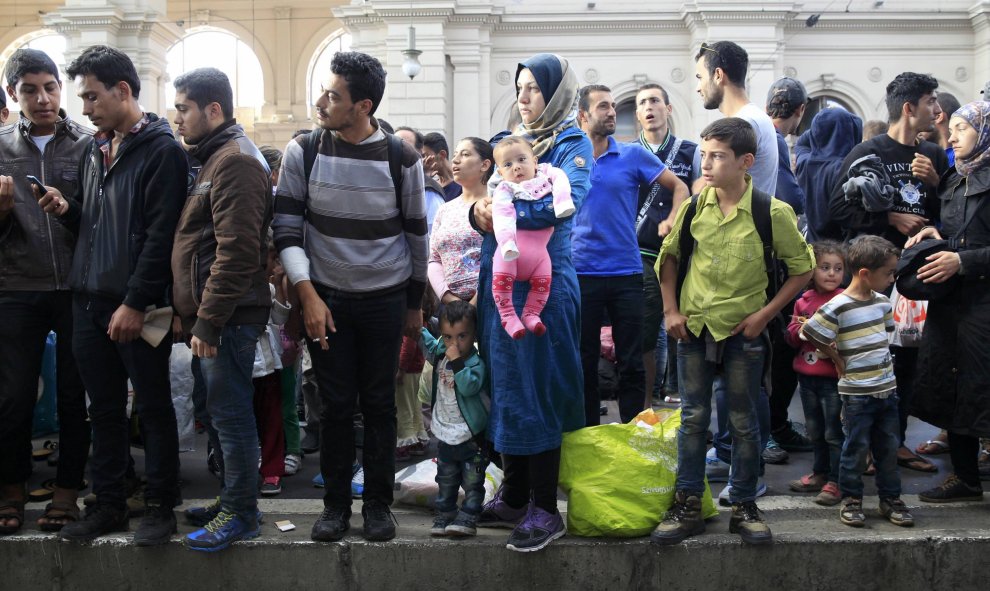 Refugiados esperan en el andén de la estación de Keleti a que llegue un tren. /REUTERS