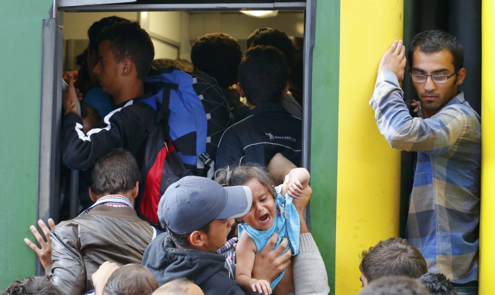 Cientos de refugiados intentan subirse a un tren en la estación de Keleti (Budapest). /REUTERS