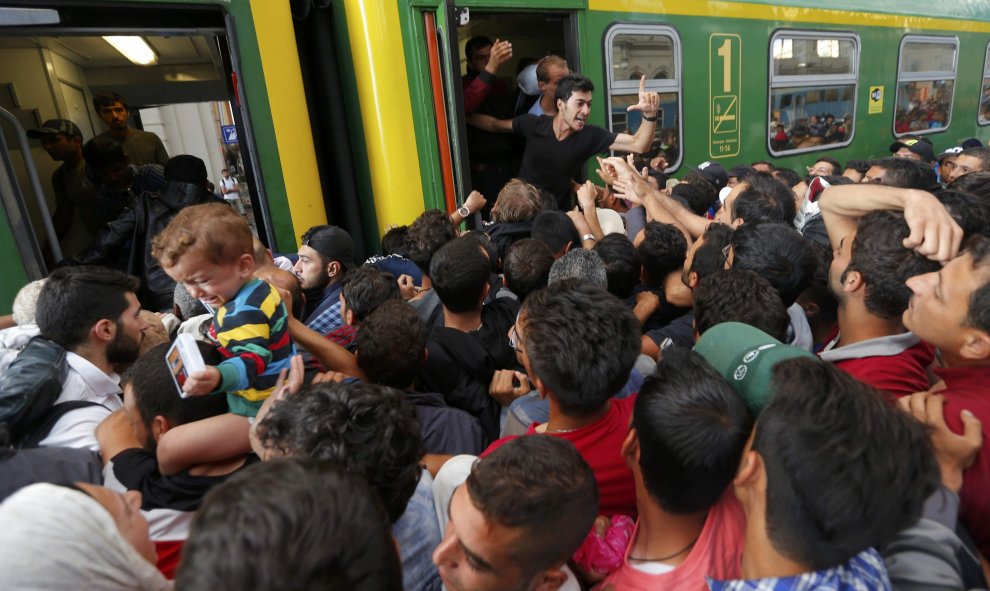 Decenas de refugiados intentan subirse a un vagón de tren entre empujones tras la autorización del Gobierno húngaro. /REUTERS