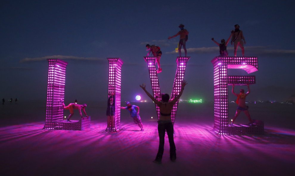 Los participantes se suben a una instalación de arte en el festival de arte y la música Burning Man 2015 "Carnaval de los Espejos" en el Desierto de Nevada. REUTERS / Jim Urquhart