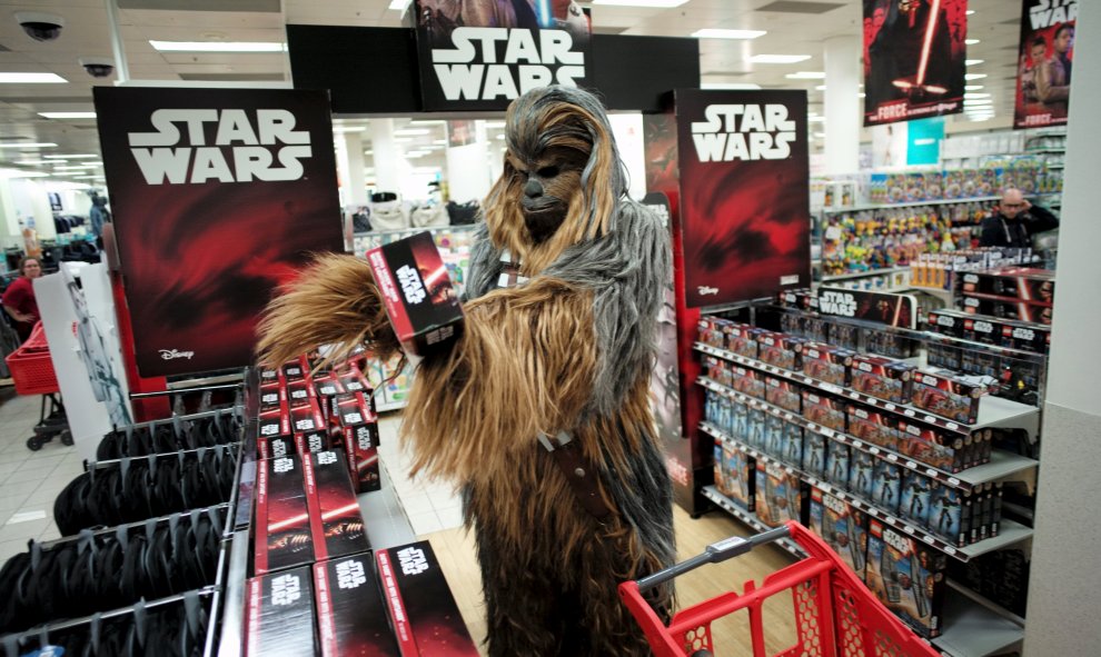 Un fan vestido como Chewbacca mirando un juego de la película Star Wars: The Force Awakens justo antes de la medianoche del 'Viernes de la Fuerza' en Sydney, 4 de septiembre de 2015. REUTERS / Jason Reed