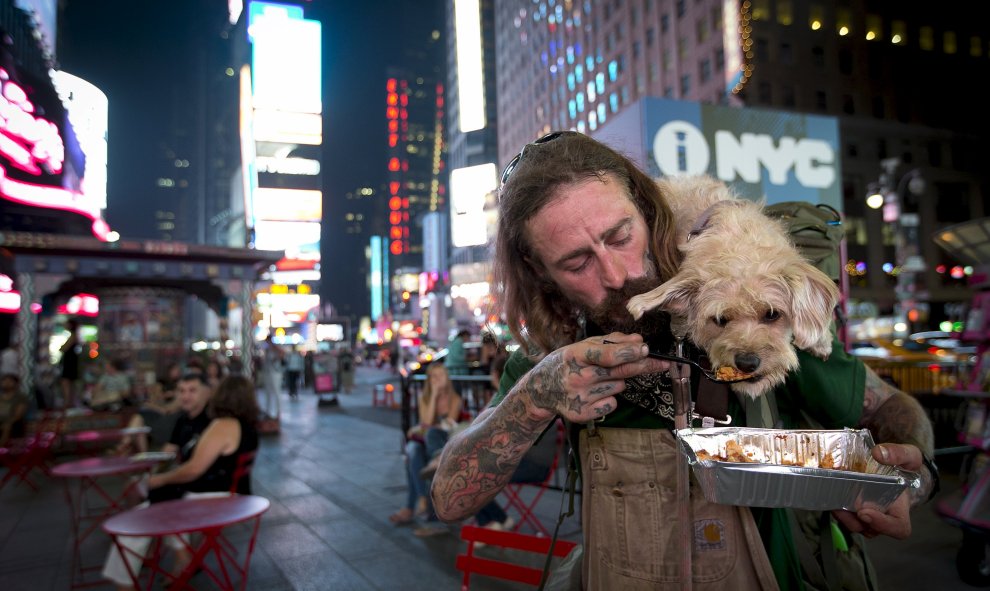 Un viajero da de comer a su perro en Times Square, Manhattan, Nueva York, 4 de septiembre de 2015. REUTERS/Carlo Allegri