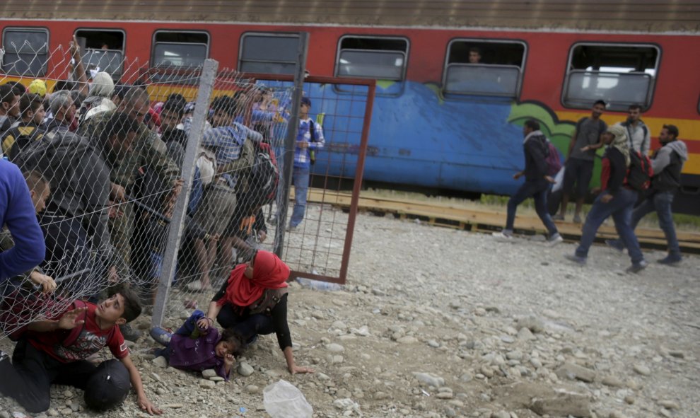 La Policía de Macedonia intenta parar a los inmigrantes que pasan la valla por debajo con el fin de coger un tren y emprender su viaje a Serbia y llegar a Hungría, para tener asilo./ REUTERS/ Stoyan Nenov