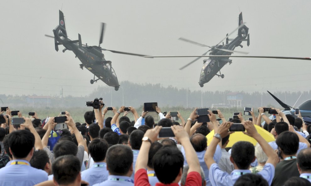 Los espectadores utilizan sus teléfonos móviles para tomar fotos y vídeos  a los helicópteros del Ejército de Liberación del Pueblo (PLA) durante una exhibición de acrobacia aérea en la Exposición Helicóptero China en Tianjin, 9 de septiembre de 2015. REU