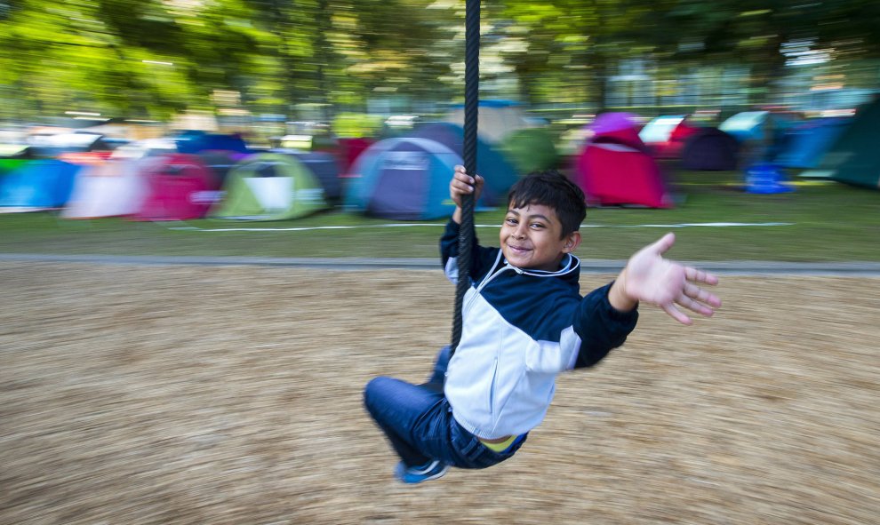 Un niño juega en un columpio en un campamento de refugiados cerca de la oficina extranjera en Bruselas, Bélgica, 09 de septiembre. REUTERS / Yves Herman