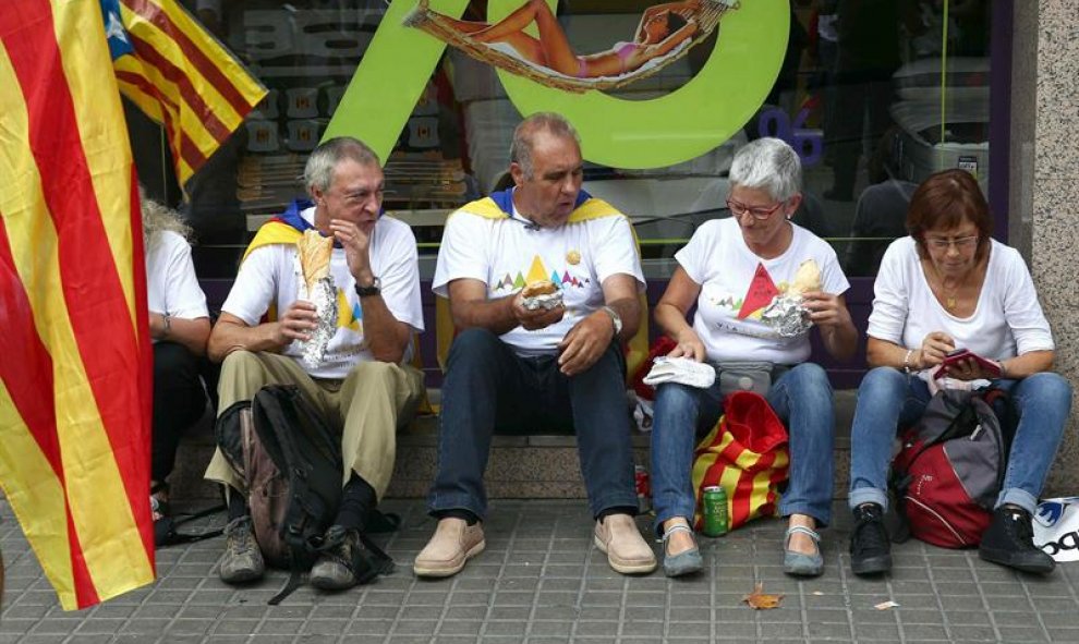 Un grupo de manifestantes come unos bocadillos en la Meridiana de Barcelona donde esta tarde se celebrará la manifestación con motivo de la Diada. EFE/Toni Albirr