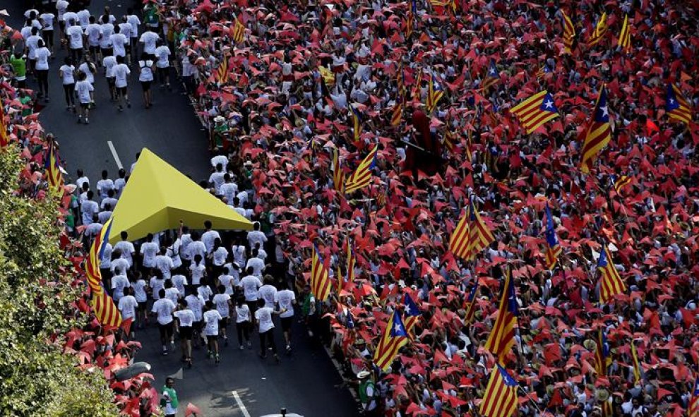 Los porteadores del puntero amarillo se dirigen hacia donde tendrán lugar los parlamentos y actuaciones. EFE/Alberto Estévez