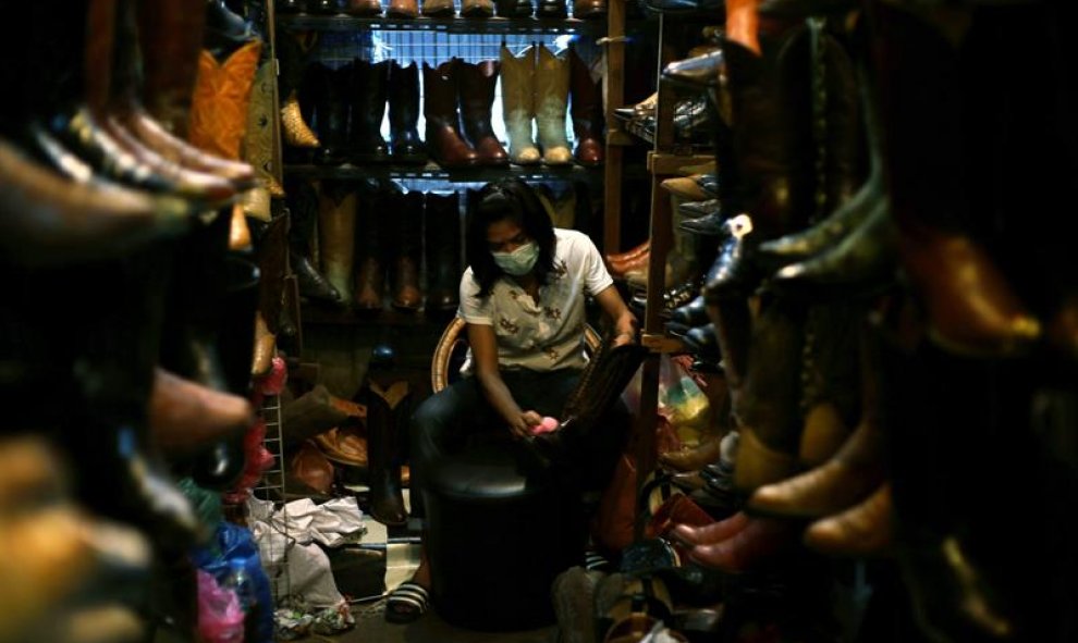 Un trabajador pule botas de cuero en el mercado de Chatuchak en Bangkok, Tailandia. EFE / RITCHIE B TONGO