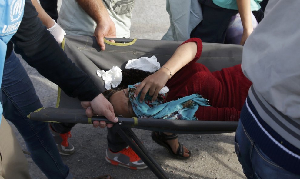 Una mujer afectada por los gases lacrimógenos es trasladada en camilla. REUTERS