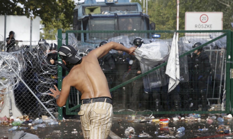 Migrantes reaccionan a los gasos lacrimógenos lanzados por la Policía húngara. REUTERS