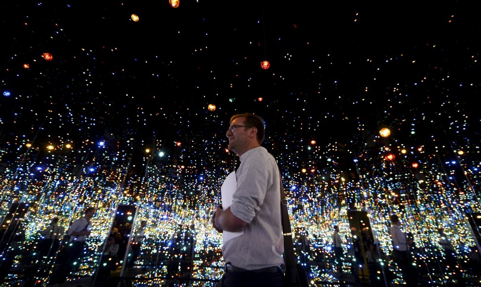 Un asistente en el Yayoi Kusama "Infinity Mirrored Room" en el interior del Broad Museum durante una presentación a la prensa en Los Ángeles, California. El nuevo museo construido por Eli y Edythe Broad, abrirá con su colección de arte moderno al público