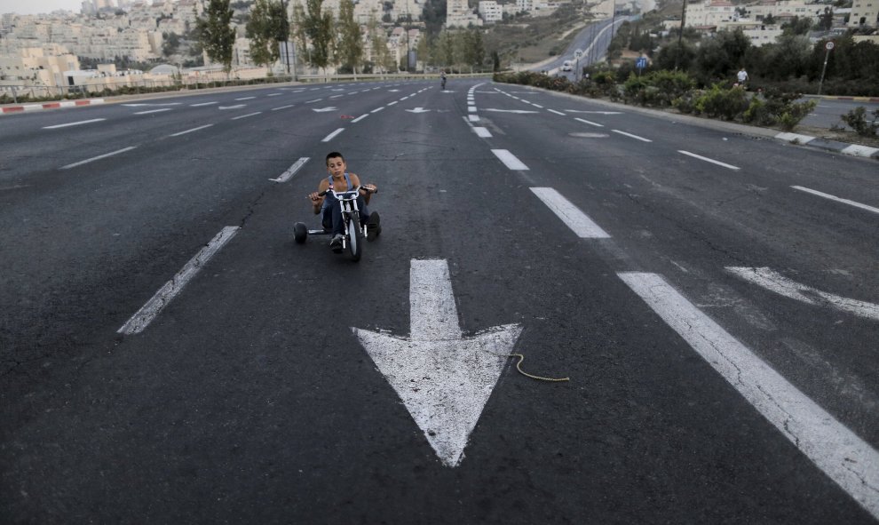 Un niño montado en su triciclo en una calle desierta durante la fiesta judía  Yom Kippur. REUTERS/Ammar Awad