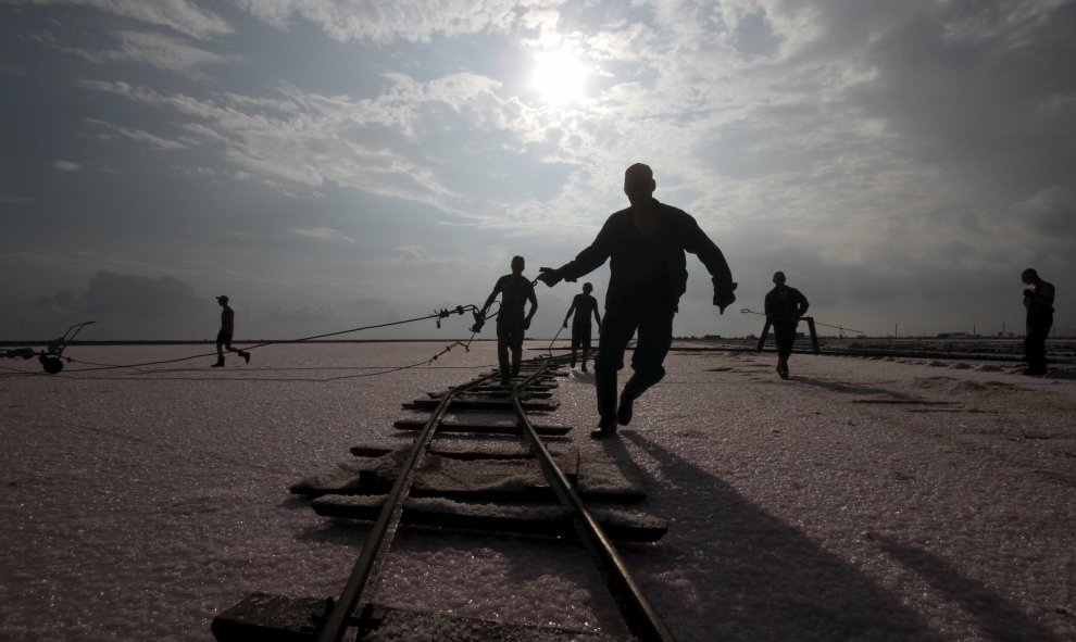 Trabajadores ajustan unos carriles en el área drenada de un lago en Sasyk (Crimea) utilizados para la producción de sal. REUTERS