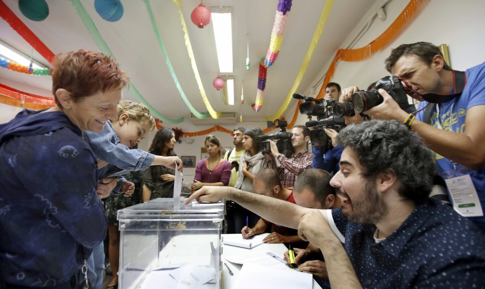 Un niño, en brazos de su madre, deposita el voto en la urna en una mesa del Centro Cívico El Turó de Sant Vicenç dels Hors (Barcelona), en las elecciones autonómicas del 27-S. EFE/Andreu Dalmau