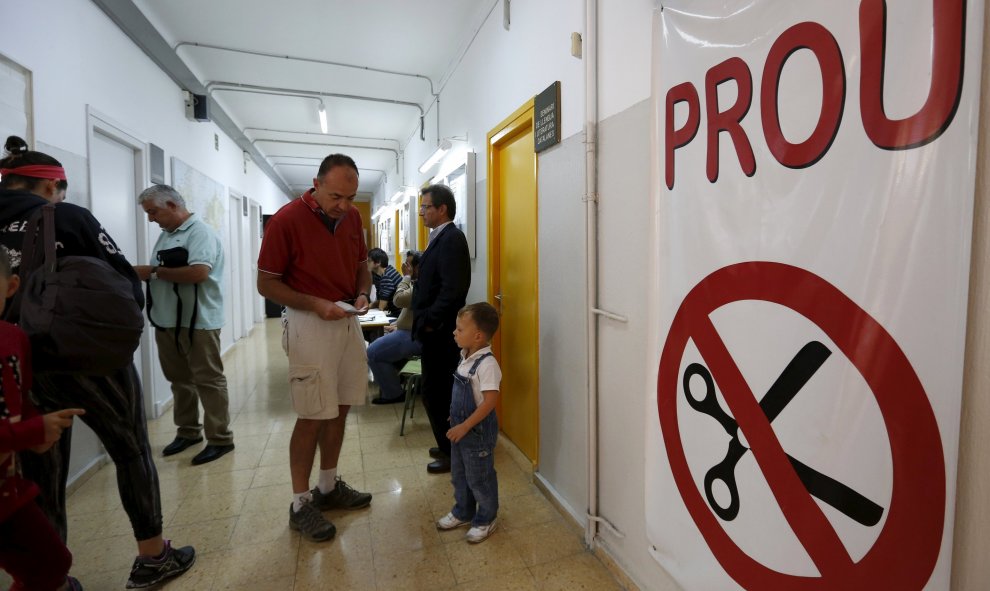 Un hombre se prepara a salir después de haber votado con su hijo en un colegio electoral en Barcelona, en las autonómicas del 27-S. REUTERS/ Gustau Nacarino
