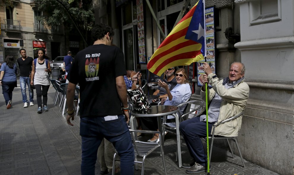 Un hombre con la bandera estelada, el símbolo del independentismo catalán, en una terraza de un bar en Barcelona. REUTERS/Andrea Comas