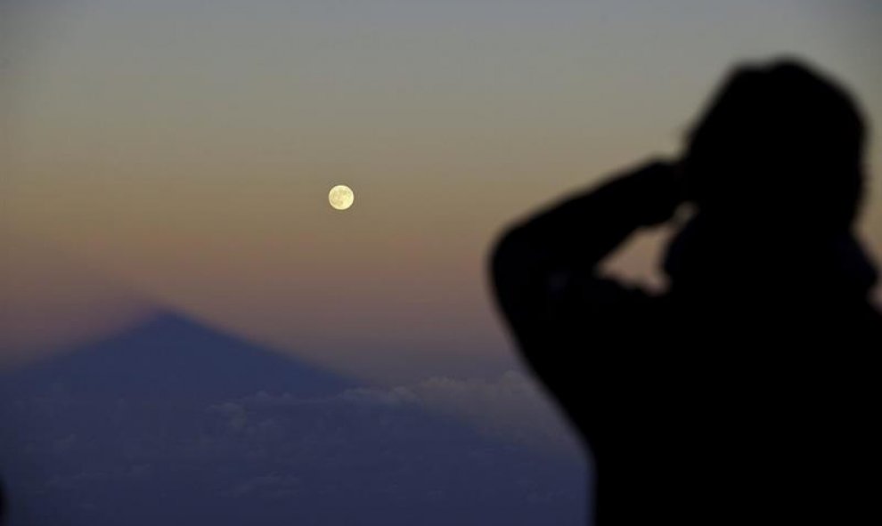 Un hombre contempla como la sombra del volcán Teide, en la isla de Tenerife, se alinea con la superluna. Durante la próxima madrugada se producirá un eclipse total de Luna. EFE/Ramón de la Rocha