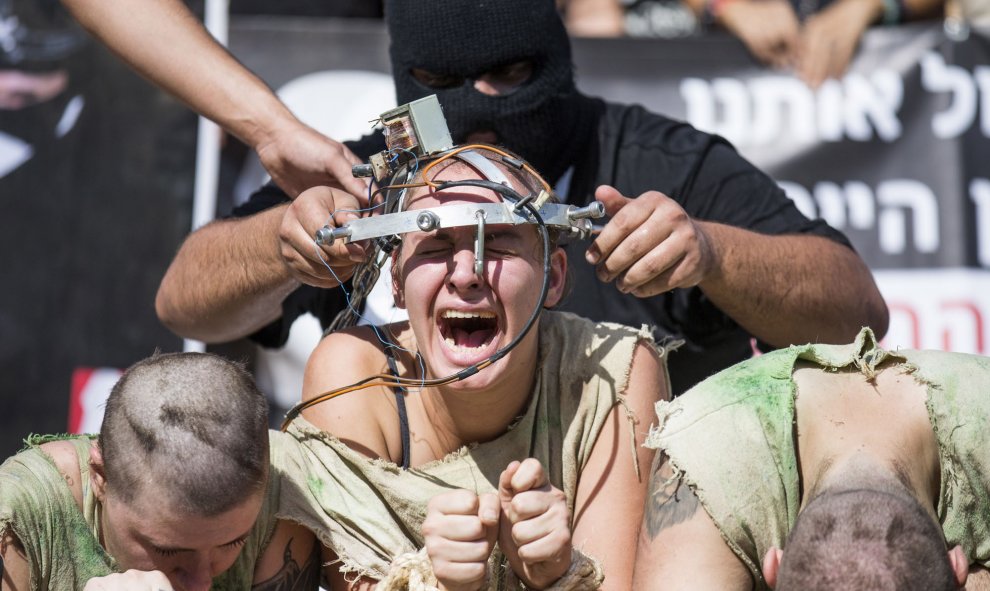 "Electrocutan" a un activista israelí en una interpretación del abuso animal en una protesta para apoyar los derechos animales en Tel Aviv, Israel. AFP PHOTO / JACK GUEZ