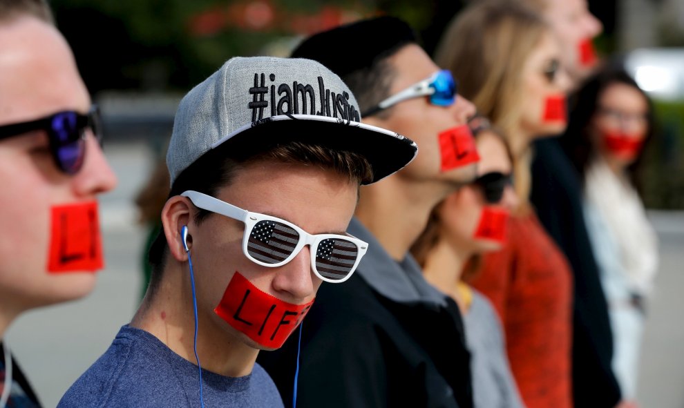Miembros del grupo antiabortista 'Bound 4 Life' protestan con cinta roja sobre la boca en la que se puede leer "La vida", delante del edificio de la Corte Suprema de Estados Unidos, en Washignton, 5 de octubre de 2015. REUTERS / Jonathan Ernst