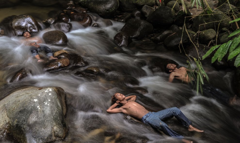 Jóvenes malasios se refrescan en un río mientras las escuelas permanecen cerradas debido a las condiciones brumosas en Hulu Langat el 6 de octubre de 2015. AFP PHOTO / MOHD RASFAN