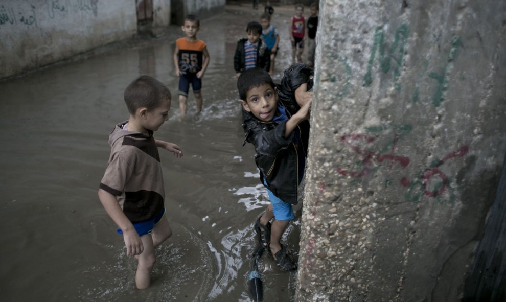 Niños palestinos en una calle inundada después de fuertes lluvias en Khan Yunis, en el sur de la Franja de Gaza el 07 de octubre de 2015. AFP PHOTO / SAID KHATIB
