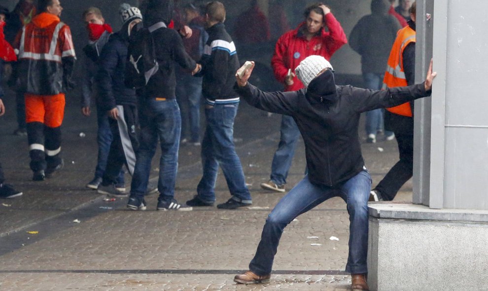 Un manifestante lanza piedras contra la Policía durante una manifestación contra la austeridad en Bruselas.- REUTERS/Yves Herman