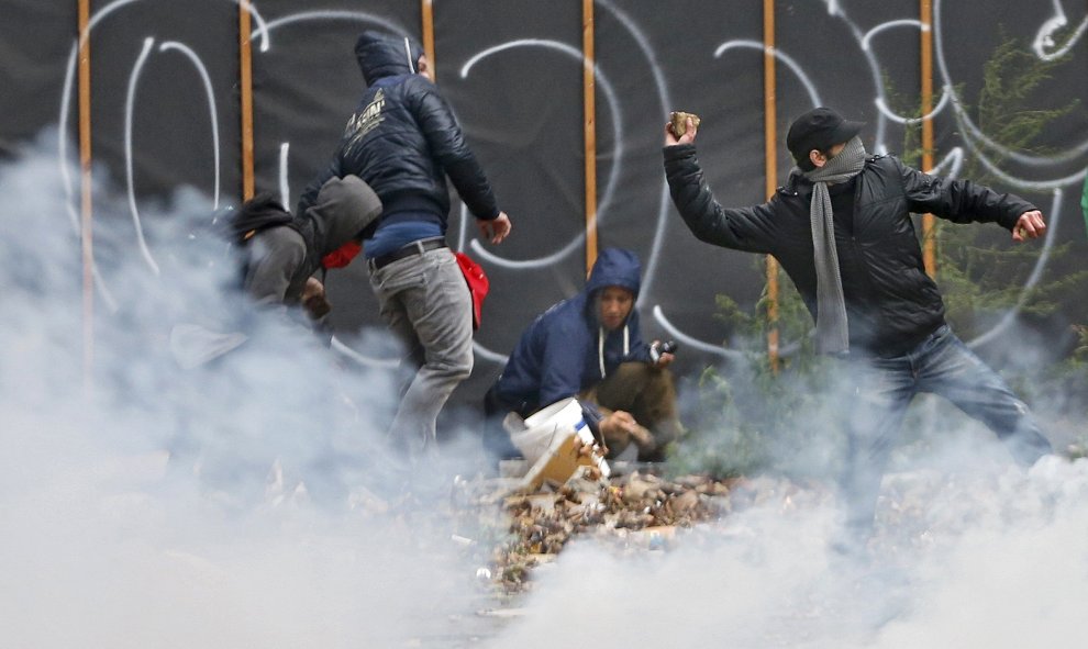 Varios manifestantes lanzan piedras contra la Policía durante una manifestación contra las reformas del Gobierno en Bruselas.- REUTERS/Francois Lenoir