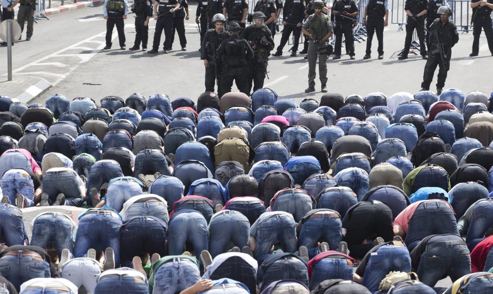 Policías fronterizos hacen guardia frente a un grupo de palestinos durante los rezos del viernes en Jerusalén (Israel) hoy, 9 de octubre de 2015. EFE/Abir Sultan