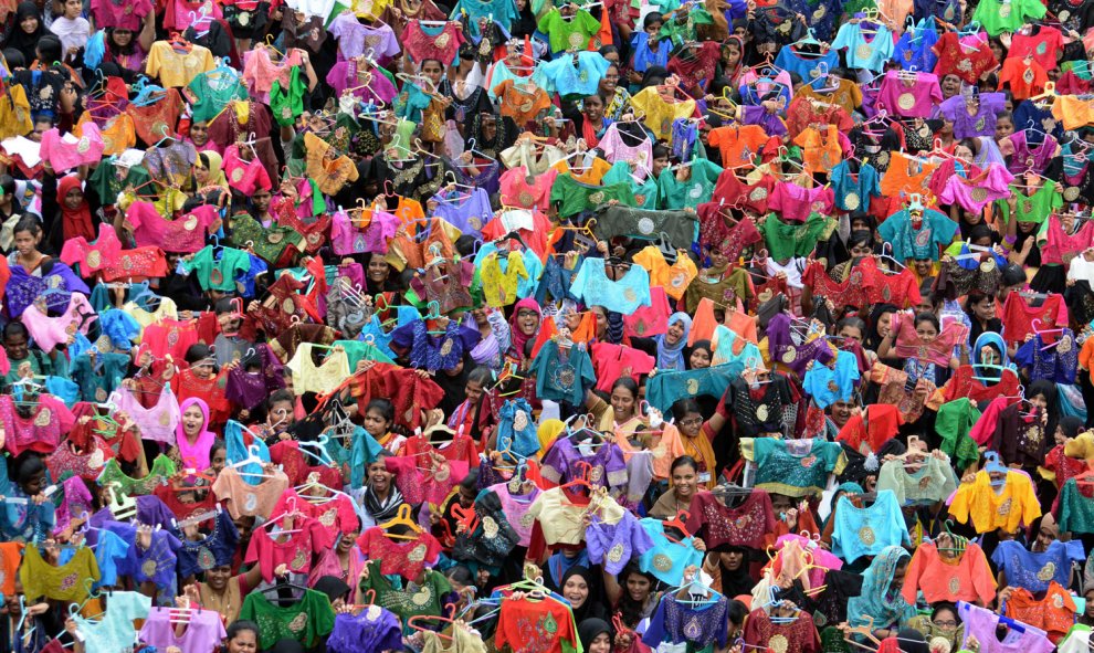 Estudiantes indios sostienen blusas pintados y decorados en un colegio en Chennai. AFP PHOTO/STR