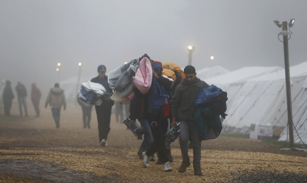 Varios refugiados trasladan sus pertenencias al abandonar un refugio temporal con temperaturas que rozan los cero grados cerca de Schwarzenborn (Alemania). REUTERS/Kai Pfaffenbach